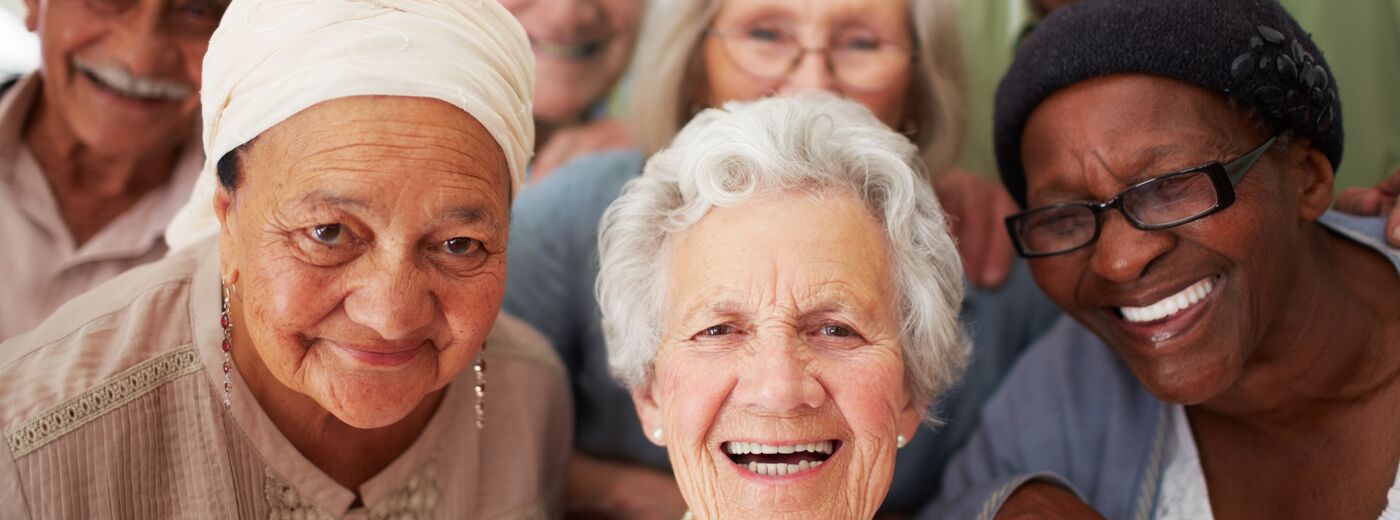 A group of seniors smiling together while in a retirement home