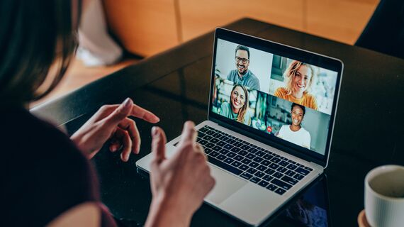 Shot of young woman talking to her friends in video call from home. Multi-ethnic group of people using laptop for a online meeting in video call. Friends having online conversation during quarantine.